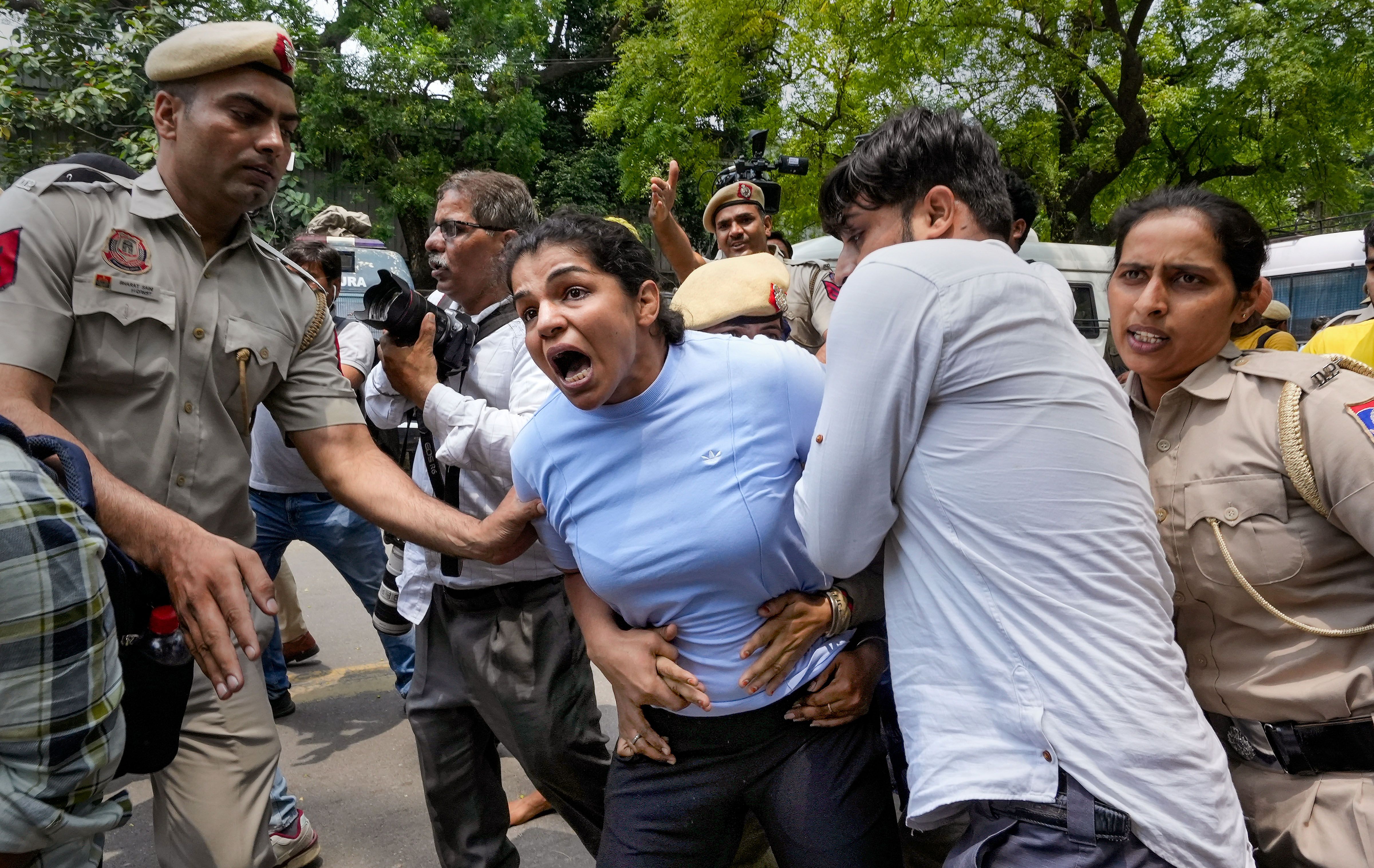 Security personnel detain wrestler Sakshi Malik during wrestlers' protest