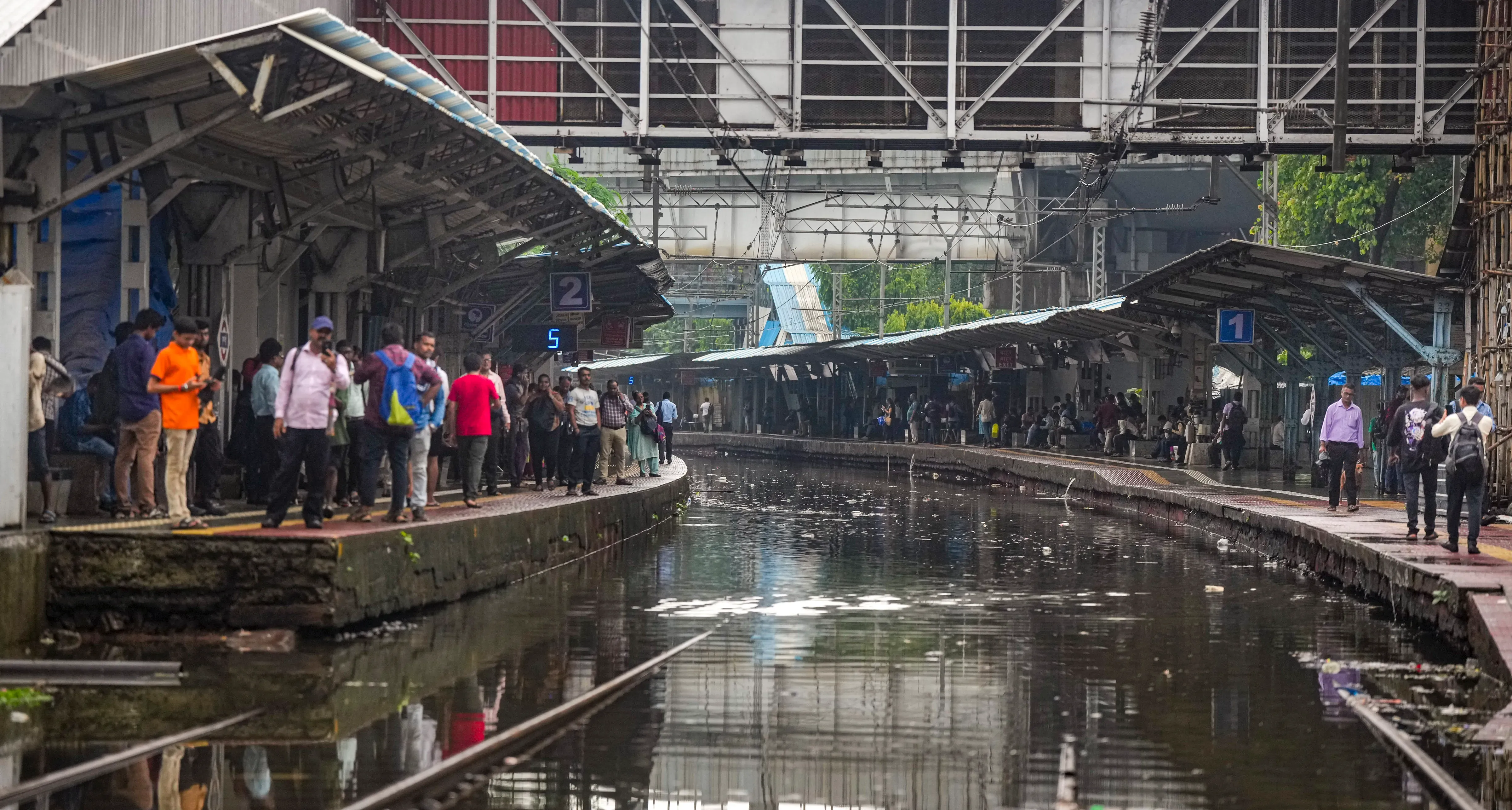 Passengers wait for trains