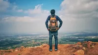 Man Standing At The Edge Of A Cliff And Staring At Clouds