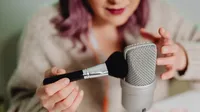 A close up of a woman stroking a brush on a mic.