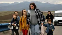 A family walk along the road from Nagorno-Karabakh to the Armenian border town of Kornidzor, September 26, 2023 (AP)