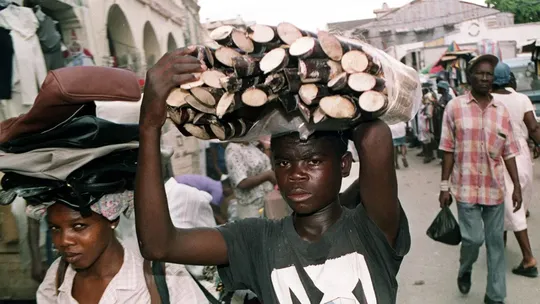 A boy carrying a bundle of sugarcane in Haiti (Photo- Getty)