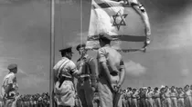 इज़रायली आर्मी के असफर 14 मई 1948 को इज़रायल का झंडा फहराते हुए (AFP)