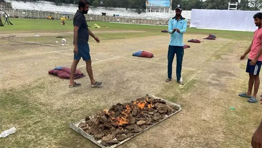 Groundsmen were seen drying the pitch of Moin-ul-Haq Stadium by burning cow dung cakes.