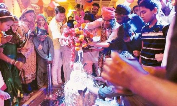 पाकिस्तान के रत्नेश्वर मंदिर में महादेव पर जल चढ़ाते हुए लोग. फोटो क्रेडिट: मोहम्मद अली