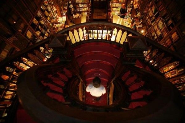 A visitor walks up a stairway at the Lello Bookshop in Porto September 25, 2010. Designed by engineer Xavier Esteves, the neo-Gothic style bookshop was opened in 1906 and is visited by thousands of tourists every year. Picture taken September 25, 2010. REUTERS/Rafael Marchante (PORTUGAL - Tags: TRAVEL SOCIETY)