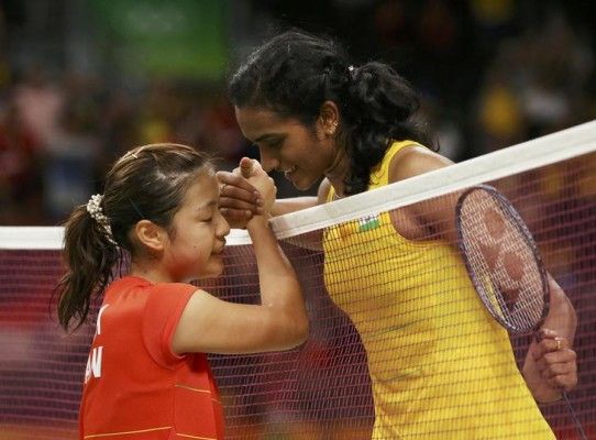 नोजोमी को हराने के बाद हाथ मिलाते, मुस्कुराती हुईं सिंधू. फोटो क्रेडिट: REUTERS