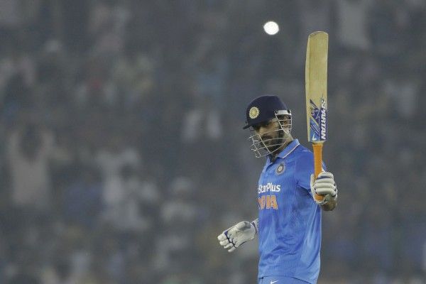 India's captain Mahendra Singh Dhoni raises his bat after scoring half a century during the third one-day international cricket match against New Zealand in Mohali, India, Sunday, Oct. 23, 2016. (AP Photo/Tsering Topgyal)