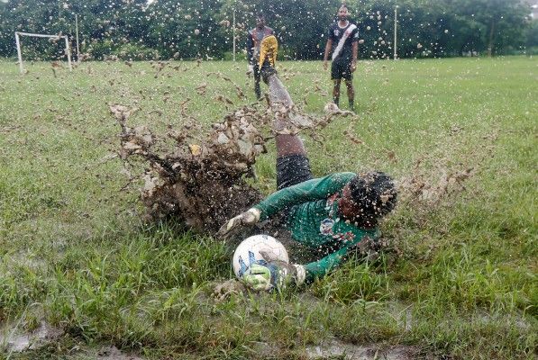A man dives to catch the ball during a soccer practice in a public park in Kolkata, India, July 27, 2016. REUTERS/Rupak De Chowdhuri - RTSJUI8
