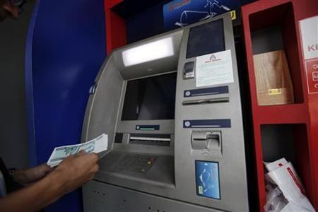 A man uses an ATM machine at KBZ bank's head office in Yangon March 14, 2012. REUTERS/Soe Zeya Tun/Files