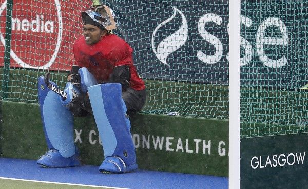 India's goalie Raveendran sits at net during a break in the play against Australia in the men's gold medal field hockey match at the 2014 Commonwealth Games in Glasgow