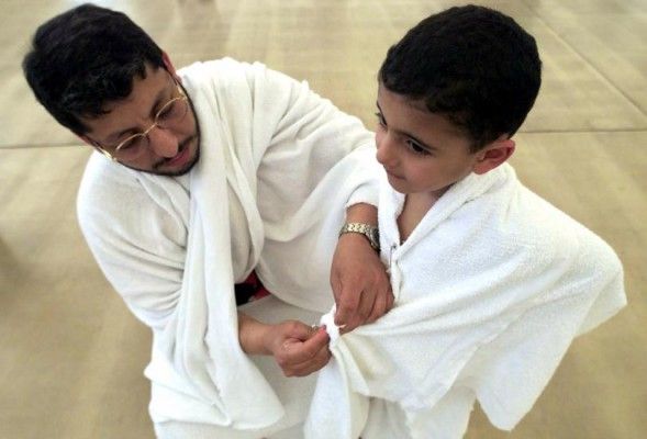 इबादत करने ले लिए बच्चे को इहराम बांधकर तैयारी करते हुए. (Photo : Reuters)