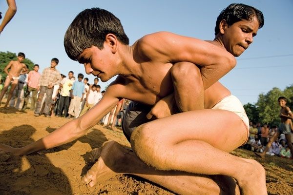 मिट्टी में कुश्ती लड़ते बच्चे. (Source:Christian Science Monitor)