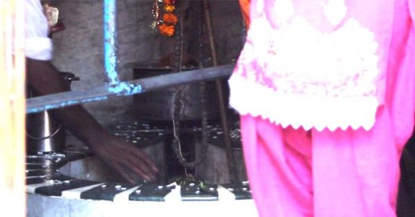 शिवलिंग की अर्चना करता एक श्रद्धालु