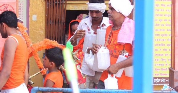 शिवलिंग पर जल चढ़ाकर बाहर निकलते कांवड़िए