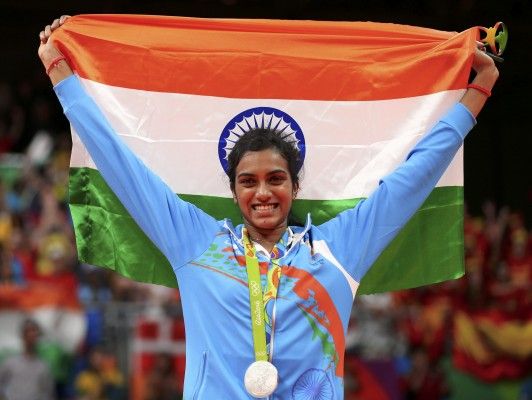 2016 Rio Olympics - Badminton - Women's Singles - Victory Ceremony - Riocentro - Pavilion 4 - Rio de Janeiro, Brazil - 19/08/2016. Silver medallist P.V. Sindhu (IND) of India poses with an Indian national flag. REUTERS/Marcelo del Pozo FOR EDITORIAL USE ONLY. NOT FOR SALE FOR MARKETING OR ADVERTISING CAMPAIGNS. - RTX2M2YR