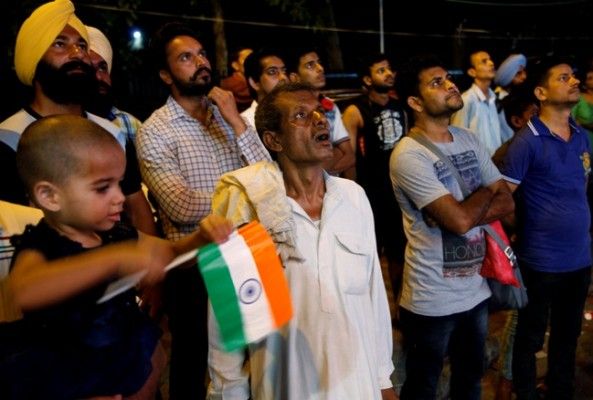 People watch the Rio Olympics final badminton match between India’s P.V. Sindhu and Carolina Marin of Spain on a screen in Chandigarh, India, August 19, 2016. REUTERS/Ajay Verma - RTX2M3L2