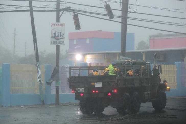 Members of the civil defense ride on a truck as Hurricane Irma howls past Puerto Rico after thrashing several smaller Caribbean islands, in Fajardo, Puerto Rico September 6, 2017. REUTERS/Alvin Baez