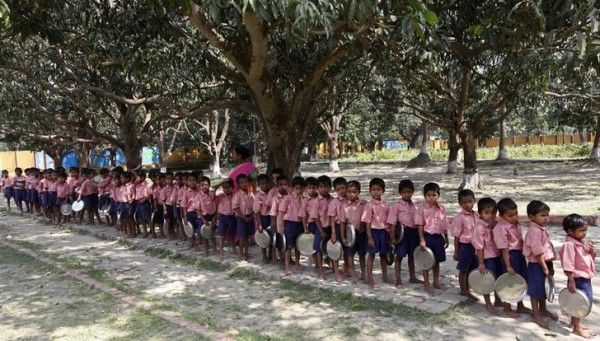 Children hold plates as they stand in line to collect their free mid-day meal distributed by a non-governmental organization inside a school in Kolkata March 3, 2012. REUTERS/Rupak De Chowdhuri (INDIA - Tags: SOCIETY EDUCATION)