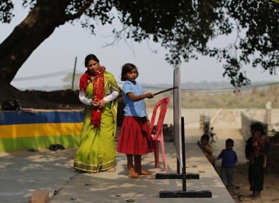 ईंट की फैक्ट्री में काम करने वाले दंपत्ति की बेटी स्कूल में बोर्ड से पढ़ते हुए. (सांकेतिक तस्वीर: रॉयटर्स)