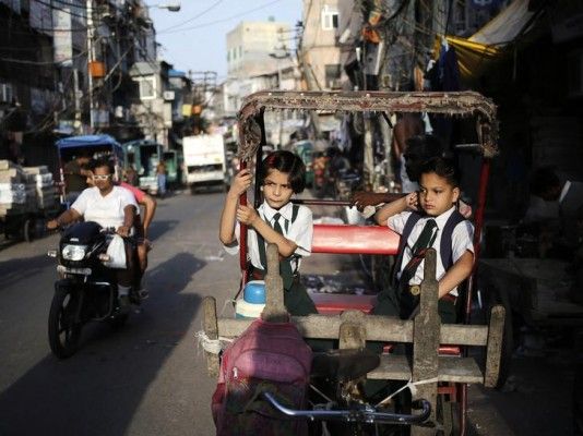 दिल्ली में रिक्शेवाले का इंतजार करते स्कूली बच्चे. (सांकेतिक तस्वीर: रॉयटर्स)