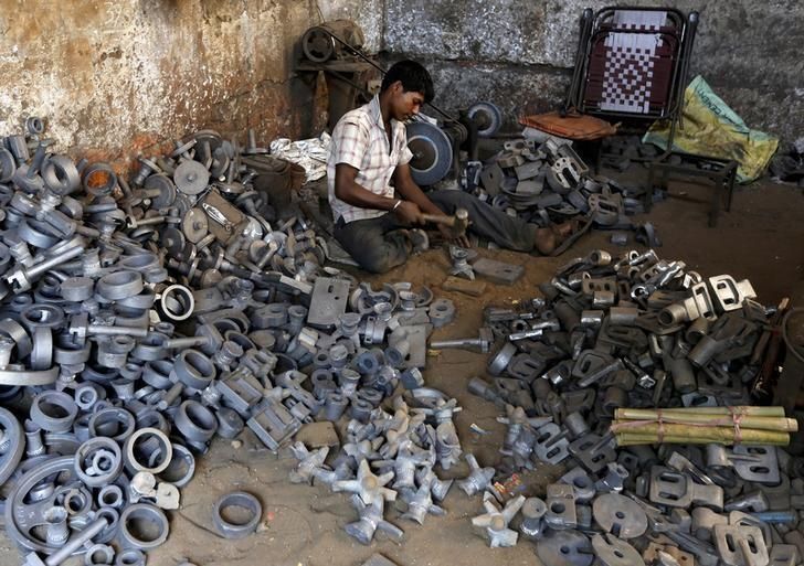 A worker separates casting joints of gearboxes inside a small-scale automobile manufacturing unit in Ahmedabad, India, October 12, 2015. REUTERS/Amit Dave/File Photo