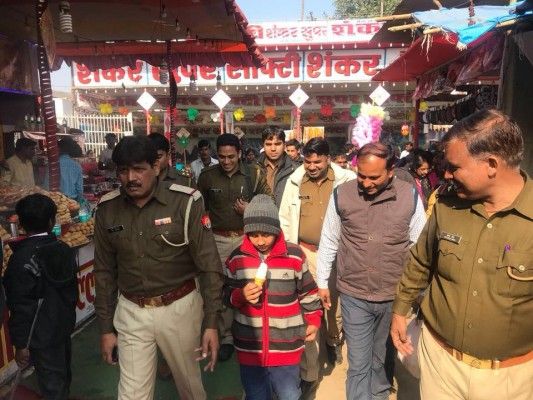 बच्चे को मेला घुमाती पुलिस.