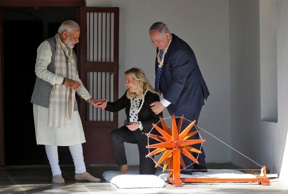 Indian Prime Minister Narendra Modi assists Israeli Prime Minister Benjamin Netanyahu's wife Sara as Netanyahu looks on during their visit to Gandhi Ashram in Ahmedabad, India, January 17, 2018. REUTERS/Amit Dave - RC1710FC57F0