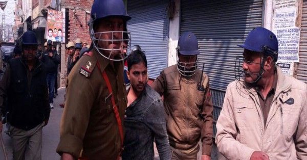 बवाल करने वाले को पकड़कर ले जाती पुलिस