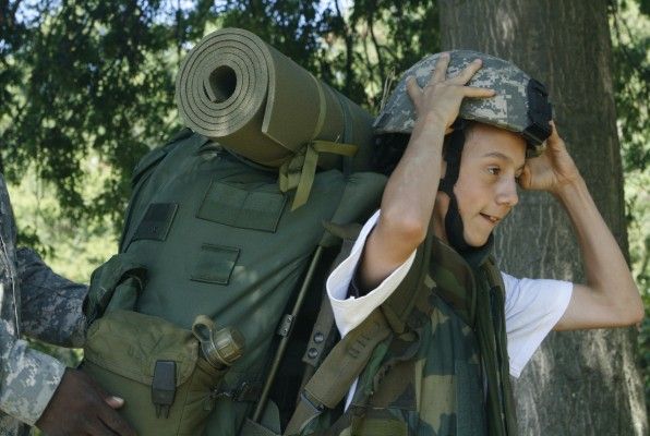 A young camper tries out a backpack, flak jacket and helmet during a relay race at an Operation Purple Summer Camp in Chestertown, Maryland August 20, 2008. The free camps attended by 10,000 children around the U.S. offer a week of outdoor activities and the chance to bond with other children of service men and women deployed in Iraq and Afghanistan. Picture taken August 20, 2008. To match feature USA-MILITARY/KIDS. REUTERS/Claudia Parsons (UNITED STATES) - GM1E48R0ETZ01