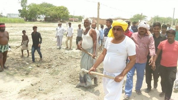 ओम प्रकाश राजभर फावड़ा लेकर सड़क बनाने में जुटे हुए हैं.