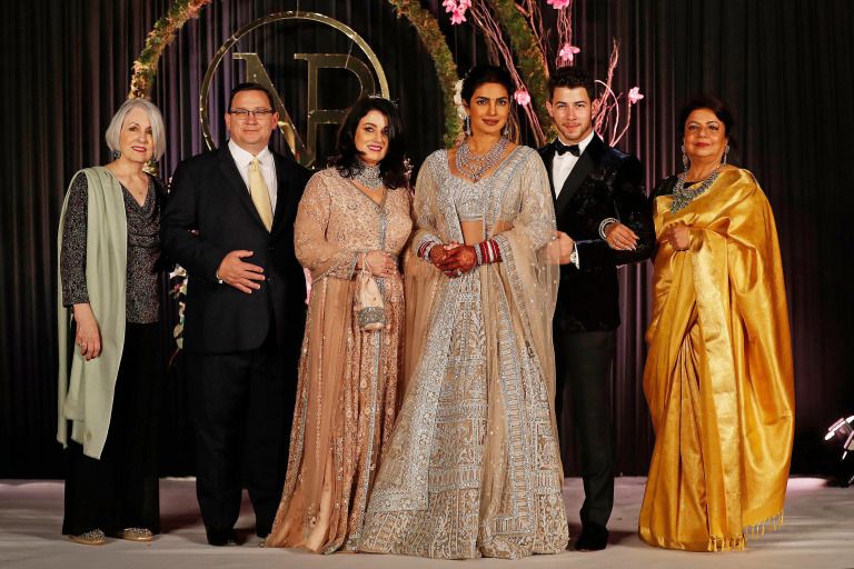 Mandatory Credit: Photo by Altaf Qadri/AP/REX/Shutterstock (10013599l) Priyanka Chopra, Nick Jonas. Bollywood actress Priyanka Chopra, third right and musician Nick Jonas, second right, stand for family photographs at their wedding reception in New Delhi, India Chopra Jonas Wedding, New Delhi, India - 04 Dec 2018