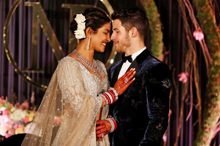 Mandatory Credit: Photo by Altaf Qadri/AP/REX/Shutterstock (10013599a) Priyanka Chopra, Nick Jonas. Bollywood actress Priyanka Chopra and musician Nick Jonas stand for photographs at their wedding reception in New Delhi, India Chopra Jonas Wedding, New Delhi, India - 04 Dec 2018
