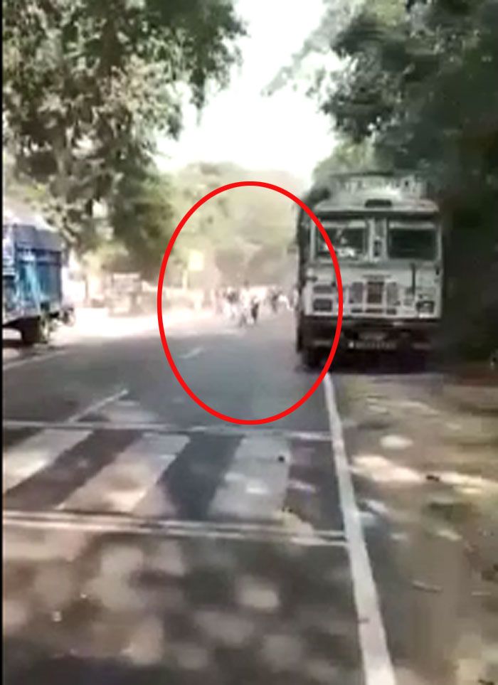 इस फ्रेम में हमको सड़के के एक ओर से भीड़ दौड़कर चौकी की तरफ आती दिखती है. इसी भीड़ के साथ वो लड़का भी दिखता है, जिसे आगे चलकर गोली लगती है. 