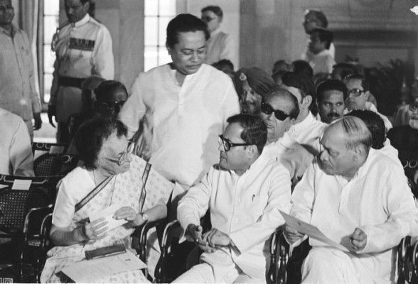 इंदिरा गांधी के साथ बैठे चश्मा लगाए शख़्श प्रणब दा हैं.