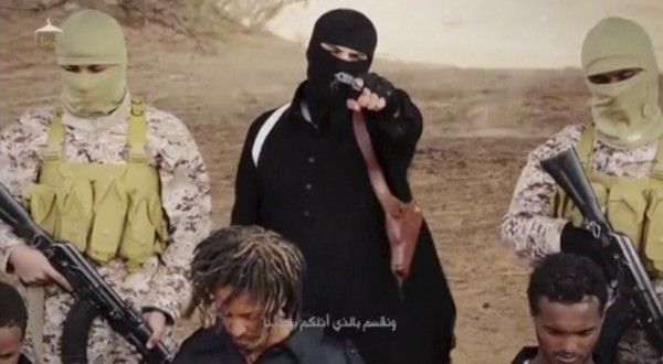 An Islamic State militant holds a gun while standing behind what are said to be Ethiopian Christians in Wilayat Fazzan, in this still image from an undated video made available on a social media website