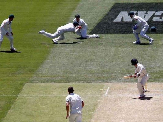 Australia's captain Steve Smith (top) takes a catch in front of team-mate Shaun Marsh to dismiss New Zealand's Bradley-John Watling (R) for seven runs during the third day of the third cricket test match at the Adelaide Oval, in South Australia, November 29, 2015. REUTERS/David Gray - RTX1WAXI